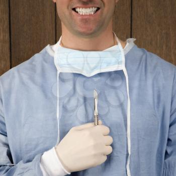 Royalty Free Photo of a Surgeon Holding a Scalpel and Smiling