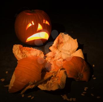 Upset jack-o'-lantern looking at smashed pumpkin.