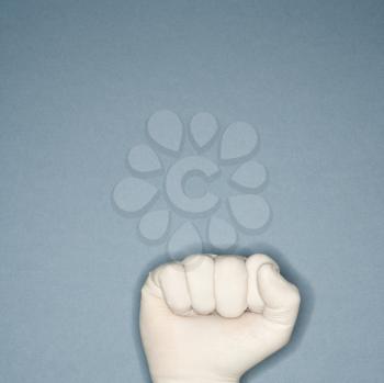 Royalty Free Photo of a Fist Wearing a White Rubber Glove