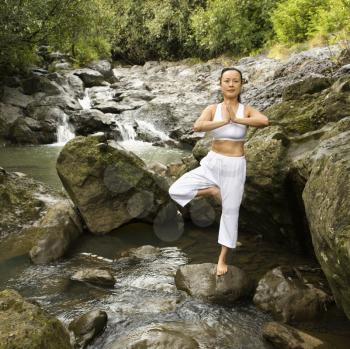 Royalty Free Photo of a Woman Doing Yoga Balancing on a Boulder by Creek in Maui, Hawaii