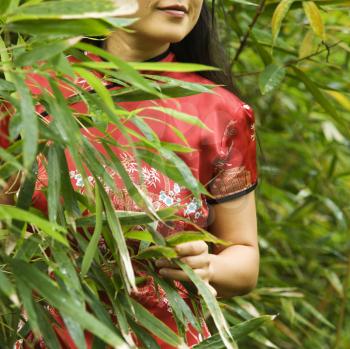 Royalty Free Photo of an Asian American Woman in Ethnic Attire in a Bamboo Forest in Maui, Hawaii