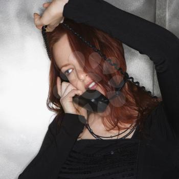 Royalty Free Photo of a Redheaded Woman With a Phone Cord Wrapped Around Her Head