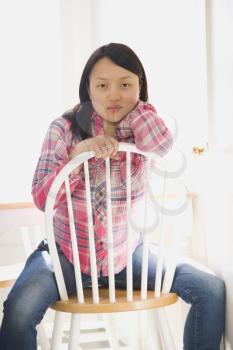 Royalty Free Photo of a Pretty Woman Sitting on a Chair at a Kitchen Table