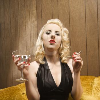 Royalty Free Photo of a Woman Holding a Martini and Smoking a Cigarette