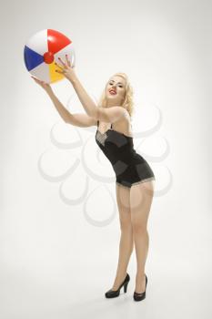 Royalty Free Photo of an Attractive Woman Wearing a Swimsuit in a Pinup Pose With a Beach Ball