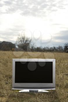 Royalty Free Photo of a Flat Panel Television Set in a Grassy Field
