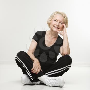 Royalty Free Photo of an Older Woman Sitting on the Floor With Legs Crossed