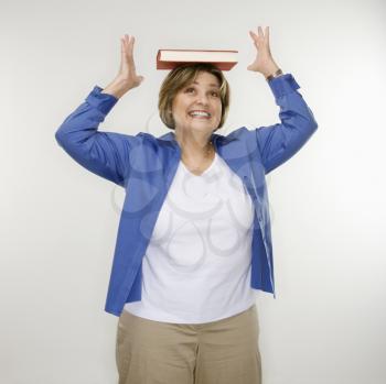 Royalty Free Photo of a Woman Balancing a Book on Her Head