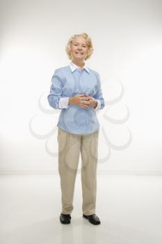 Royalty Free Photo of an Older Woman Standing With Her Hands Together