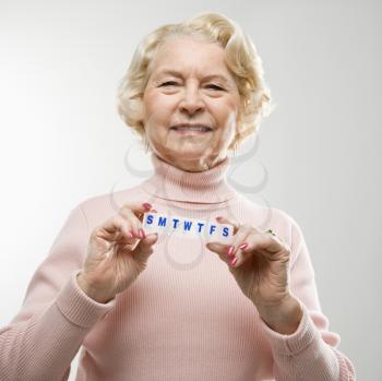 Royalty Free Photo of an Older Woman Holding a Pill Box and Smiling