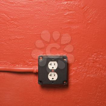 Royalty Free Photo of a Red Wall with an Electrical Outlet