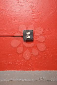 Royalty Free Photo of a Red Wall With an Electrical Outlet