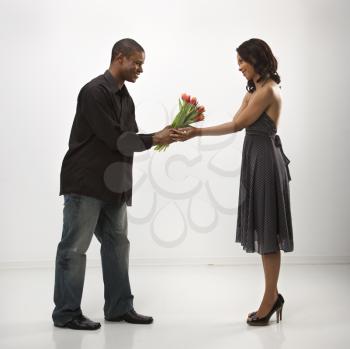 Royalty Free Photo of a Man Giving a Woman a Bouquet of Flowers