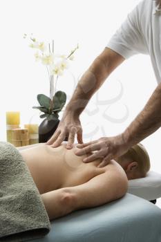 Royalty Free Photo of a Male Massage Therapist Massaging the Back of a Woman Lying on a Massage Table