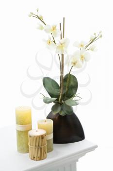 Still life of yellow candles and white lillies.