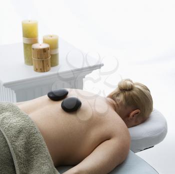 Royalty Free Photo of a Woman Lying on a Massage Table with Hot Stones on Her Back