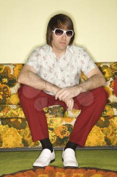 Royalty Free Photo of a Man Wearing Sunglasses Sitting on a Retro Sofa