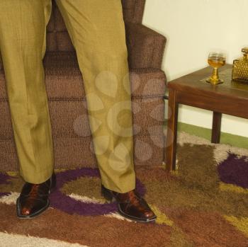 Royalty Free Photo of a Man's Legs Standing in a Retro Living Room