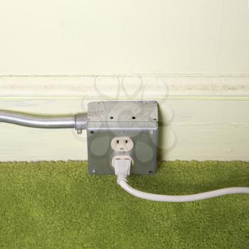 Royalty Free Photo of a Close-up of a Silver Wall Outlet With a Plug Inserted