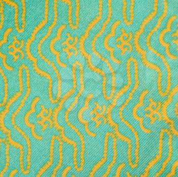 Royalty Free Photo of a Close-up of a Turquois Vintage Fabric With a Repetitive Yellow Designs Printed on Polyester