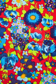 Close-up of vintage fabric with vibrant blue and turquois flowers printed on polyester.
