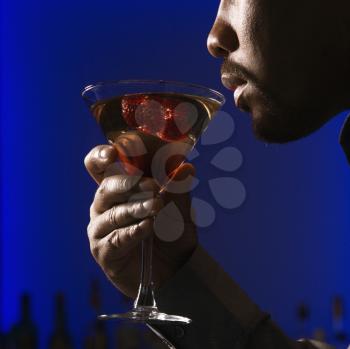 Royalty Free Photo of a Close-up Profile of an African American Man Drinking a Martini in a Bar