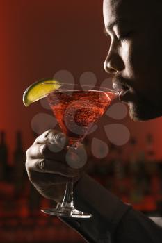Royalty Free Photo of a Close-up Profile of a Man Drinking a Martini in a Bar
