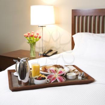 Royalty Free Photo of a Breakfast Tray Laying on a Bed in an Upscale Hotel