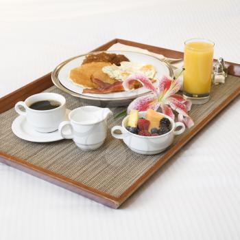 Royalty Free Photo of a Breakfast Tray Laying on a White Bed