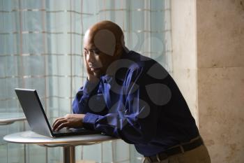 Royalty Free Photo of an African American Male Typing on a Laptop Computer
