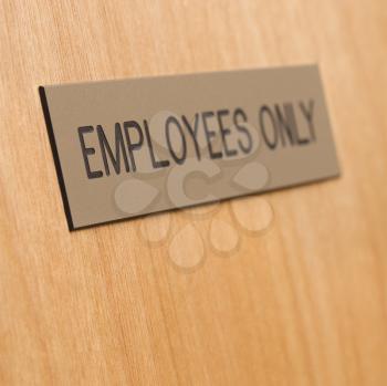 Royalty Free Photo of an Employees Only Sign on a Wooden Door