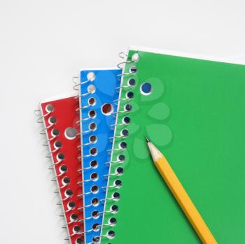 Royalty Free Photo of a Pencil Resting on Spiral Bound Notebooks