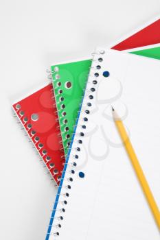 Royalty Free Photo of a Pencil on Top of Three Spiral Bound Notebooks