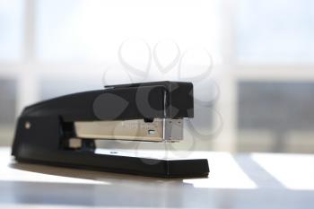 Royalty Free Photo of a Black Stapler With a Window in the Background