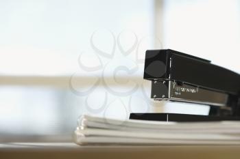 Royalty Free Photo of a Black Stapler on a Stack of Paper