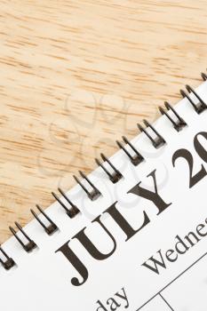 Royalty Free Photo of a Close-Up of a Spiral Bound Calendar Displaying the Month of July