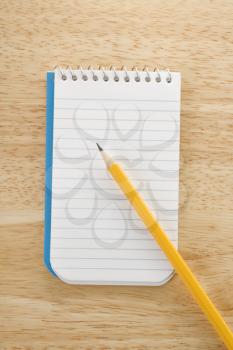 Royalty Free Photo of a Pencil on Top of a Spiral Bound Notepad