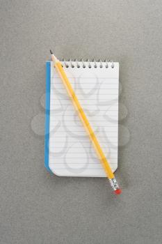 Royalty Free Photo of a Pencil on Top of an Open Spiral Bound Notepad