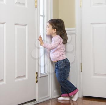 Royalty Free Photo of a Girl Toddler Peeking Out Through the Door