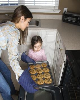 Royalty Free Photo of a Mother and Daughter Taking Cookies out of the Oven