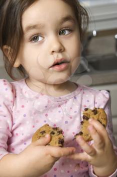 Royalty Free Photo of a Girl Eating a Chocolate Chip Cookie