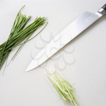 Royalty Free Photo of Fresh Chives With a Kitchen Knife Resting on a Counter Top