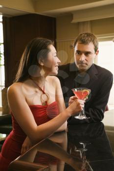 Royalty Free Photo of a Woman and Man Sitting at a Bar Talking 