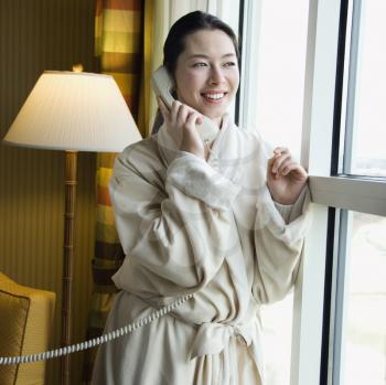 Royalty Free Photo of a Woman in a Bathrobe Talking on the Phone