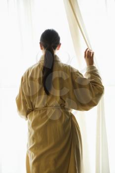 Royalty Free Photo of  a Taiwanese Woman in a Bathrobe  Looking Out the Window