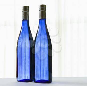 Two blue bottles with on white.