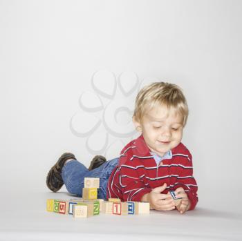 Royalty Free Photo of a Toddler Boy Lying Playing With Toys