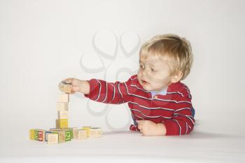 Royalty Free Photo of a Toddler Boy Laying Playing With Toys