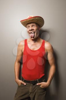 Royalty Free Photo of a Male wearing a Straw Hat Sticking Out His Tongue