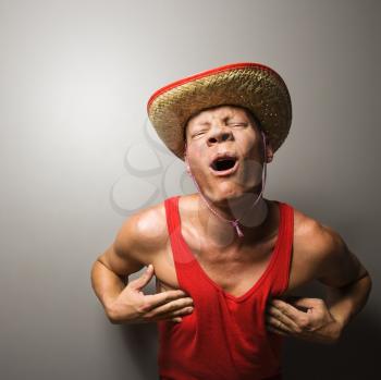 Royalty Free Photo of a Man Wearing a Straw Hat and Touching His Chest